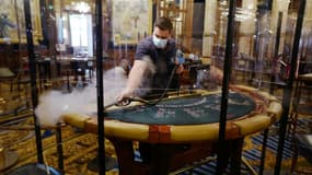 Un employé de casino désinfecte une table de blackjack avant la réouverture du casino de Monte-Carlo le 4 juin 2020 à Monaco