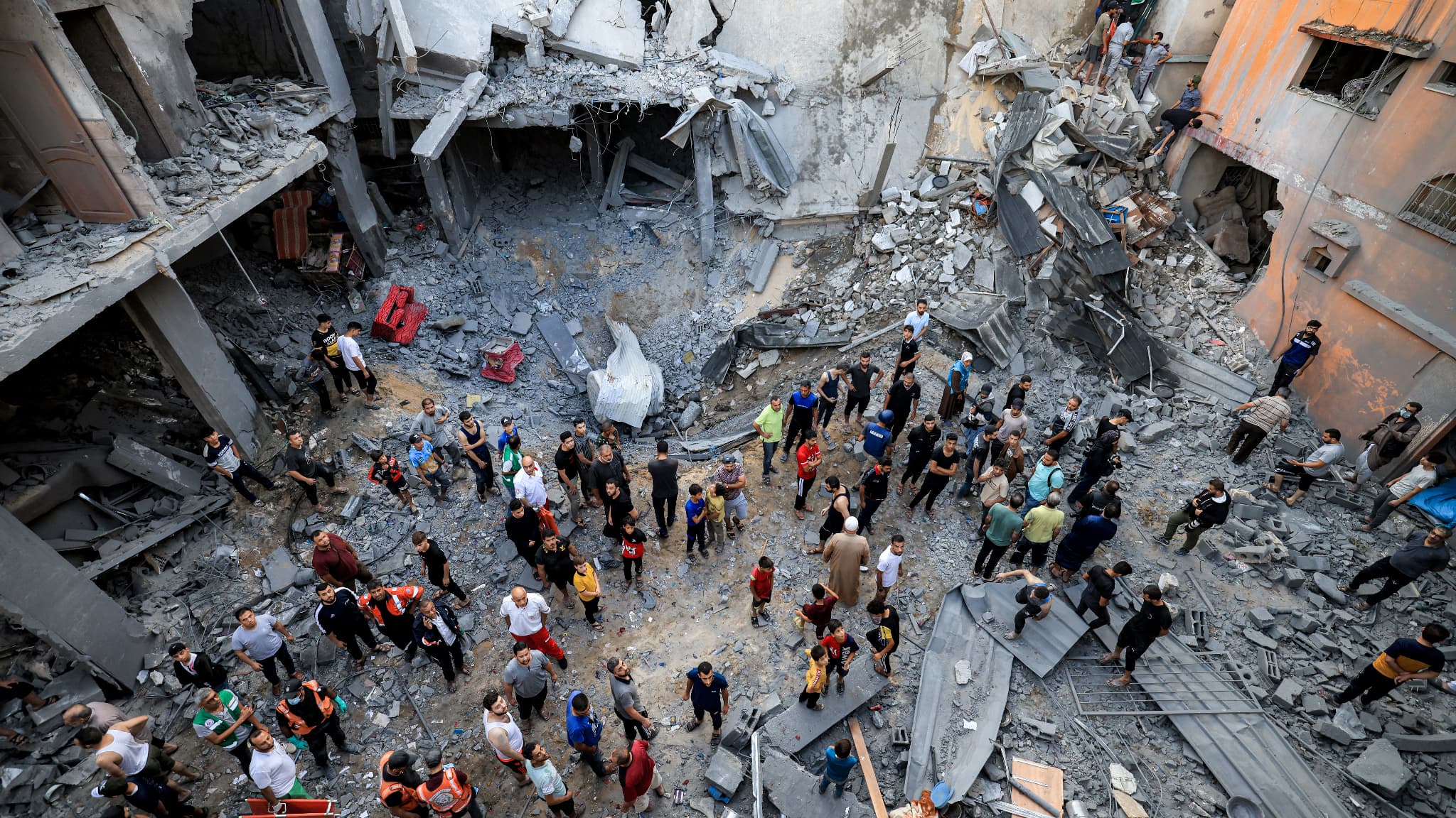 Des membres de la défense civile palestinienne et des habitants se rassemblent sur le site d'un bâtiment touché par un bombardement israélien à Khan Yunis, dans le sud de la bande de Gaza, le 19 octobre 2023.