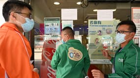 Des agents de santé affichent des panneaux dans un centre de vaccination communautaire Covid-19 Pfizer/BioNTech à Kowloon annonçant la suspension des vaccinations BioNTech à Hong Kong, le 24 mars 2021.