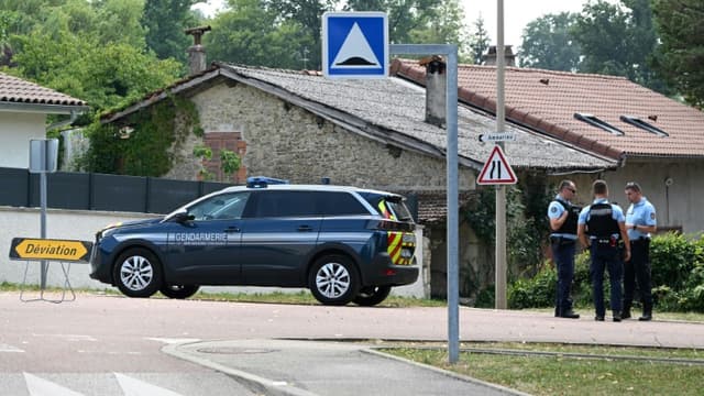 Des gendarmes bloquent une route menant à la maison où un homme a tué cinq personnes avant d'être abattu par le GIGN, le 20 juillet 2022 à Douvres, dans l'Ain