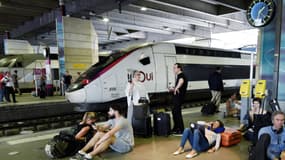 Des voyageurs attendent sur un quai de la gare Montparnasse le 27 juillet 2018, à Paris. 