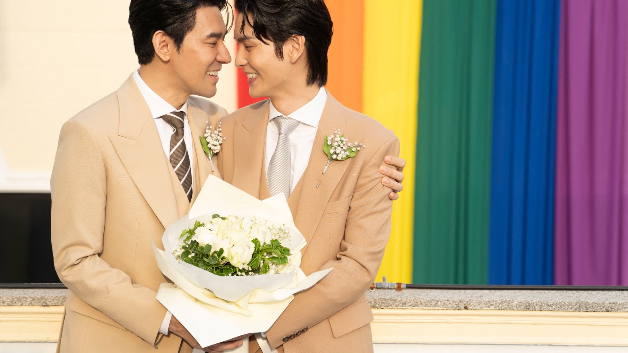 Les acteurs thaïlandais Apiwat "Porsch" Apiwatsayree (G) et Sappanyoo "Arm" Panatkool après avoir enregistré leur mariage au bureau du district de Phra Nakhon à Bangkok, le 23 janvier 2025.