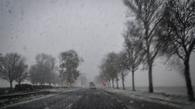 La neige tombe alors que des véhicules circulent sur une route près de Caen, dans le nord-ouest de la France, le 21 novembre 2024. 