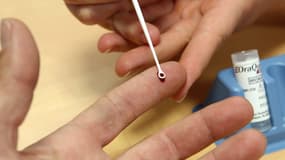 Un patient se fait prélever une goutte de sang afin de réaliser un test de dépistage à l'hépatite C, le 18 mai 2011. 