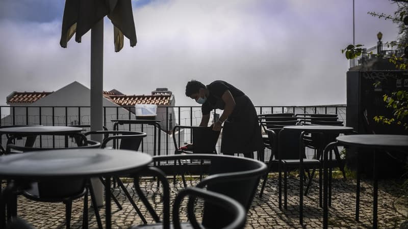 Un serveur disposant des tables sur une terrasse de Lisbonne au Portugal le 5 avril 2021.
