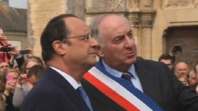 Le président François Hollande et le maire de Trévières, Jean-Pierre Richard, autour de l'église de la commune et du monument aux morts, ce dimanche.