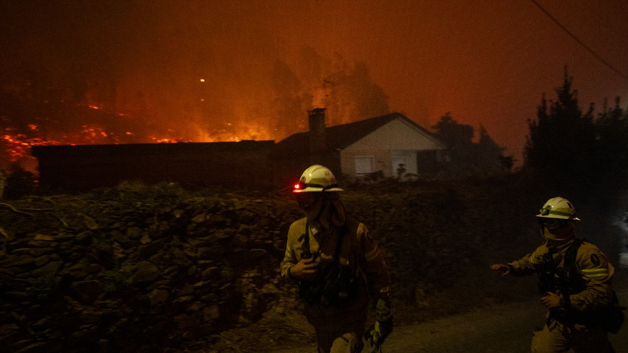 Des pompiers courent pour aider les villageois lors d'un incendie de forêt à Ribeira de Fraguas, Albergaria-a-Velha à Aveiro, le 16 septembre 2024. 