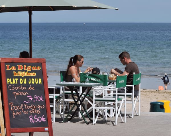 Une famille déjeune le 30 juillet 2008 à la terrasse d'un restaurant le long de la plage de Saint-Aubin-sur-Mer.