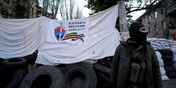 Un militant pro-russe vendredi devant le siège des services spéciaux à Slaviansk, bastion des insurgés dans l'Est de l'Ukraine.