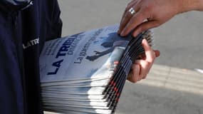 Un client s'empare de la première édition du nouvel hebdomadaire français du dimanche "La Tribune Dimanche", le 8 octobre 2023 à Paris (photo d'illustration).