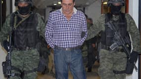 Photo du bureau du procureur général montrant Hector Beltran Leyva, entre deux policiers.
