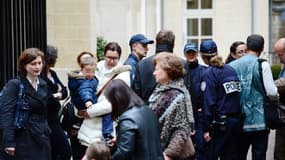 Des parents récupèrent leurs enfants à la sortie de la maternelle La Rochefoucauld, dans le VIIe arrondissement de Paris, après qu’un homme se soit suicidé dans le hall de l’établissement.