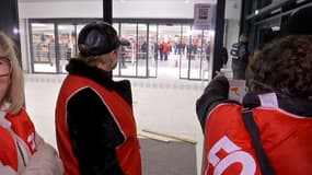 Des salariés rassemblés devant un Auchan de Valenciennes lors de son inauguration, mercredi 27 novembre 2024.