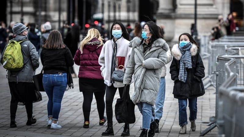 Des touristes portant un masque sanitaire près du musée du Louvre à Paris le 28 février dernier (Photo d'illustration).