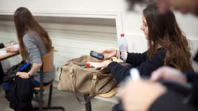 Une étudiante française éteint son téléphone portable avant l'épreuve de philosophie alors qu'elle passe le baccalauréat, le 18 juin 2012, au lycée Lavoisier à Paris. 