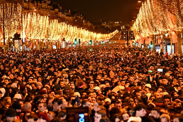 Des personnes se rassemblent sur l'avenue des Champs-Elysées pour les célébrations du Nouvel An à Paris, le 31 décembre 2023.