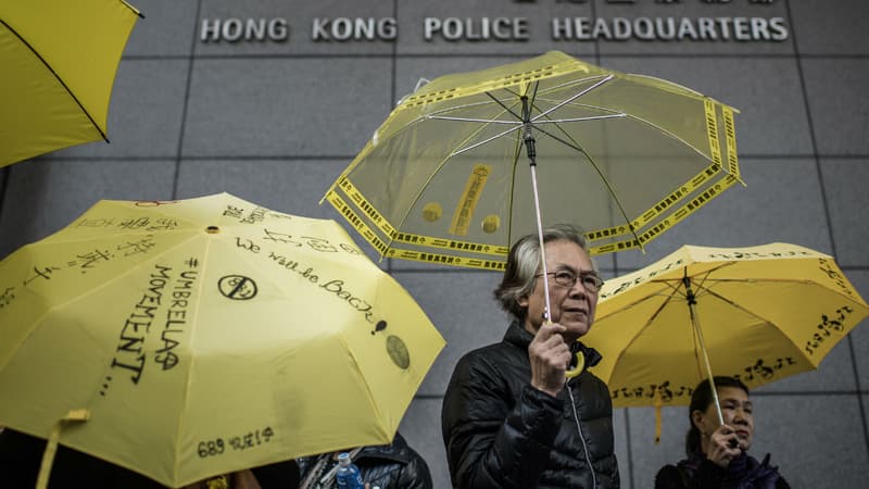 Des manifestants prodémocrates tiennent des parapluies jaunes devant le commissariat de Hong Kong