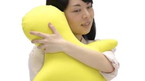 Une japonaise et son coussin, baptisé "Hugvie", photographiée le 4 juin 2015, muni d'une pochette pour accueillir un mobile, objet à étreindre en parlant que s'apprête à commercialiser une société japonaise