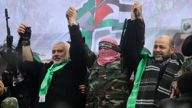 Des leaders du mouvement Hamas: Ismail Haniya (G), porte-parole des Brigades Ezzedine Al-Qassam, Abu Obaida et Moussa Abou Marzouq (D) saluent les partisans pendant un défilé marquant le 27e anniversaire de la création du mouvement islamiste le 14 Décembre, 2014 dans la ville de Gaza.