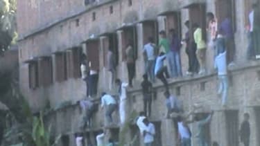 Des dizaines de personnes en train d'escalader les murs d'un centre scolaire dans l'Etat de Bihar en Inde