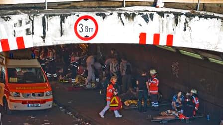 Les secours s'affairent autour de personnes blessées dans la bousculade qui a endeuillé samedi la "Love Parade" allemande, grande manifestation autour de la musique techno organisée cette année à Duisbourg. Selon un dernier bilan, au moins quinze personne