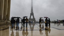 Des visiteurs s'abritent de la pluie avec des parapluies sur l'Esplanade du Tocadero en face de la Tour Eiffel, alors que les restes de l'ouragan Kirk provoquent de fortes pluies sur Paris, le 9 octobre 2024.