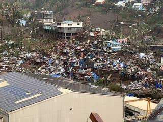 Une photo prise le 15 décembre 2024 montre un tas de débris de tôles, de bois, de meubles et d'effets personnels après le passage du cyclone Chido sur le territoire français de Mayotte, dans l'océan Indien. 