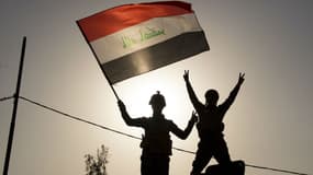 Des soldats de l'armée irakienne qui brandissent le drapeau irakien à Mossoul, le 9 juillet 2017.