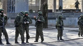 Des soldats non-identifiés lourdement armés patrouillent devant le Parlement de Crimée, à Simféropol samedi, en Ukraine.