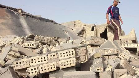 Un homme inspecte les décombres de la maison d'un policier de Falloudja, détruite lundi par un attentat. Des explosions et des attentats suicide ont frappé Bagdad et plusieurs villes des environs lundi matin, faisant une trentaine de morts. /Photo prise l