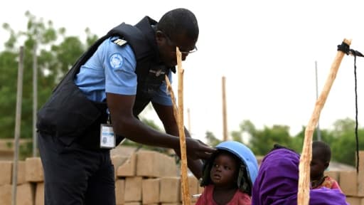 Un Casque bleu de la Minusma prête son casque à un enfant à Gao, au Mali, le 3 août 2018