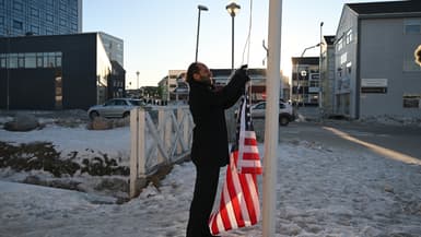 Le comédien allemand Maxi Schafroth tente de hisser un drapeau américain dans la ville de Nuuk, dans l'ouest du Groenland, le 28 janvier 2026. 