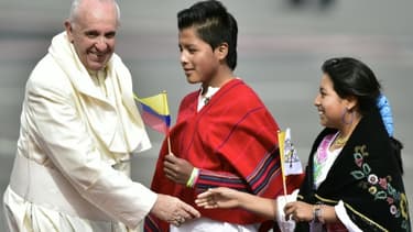 Le pape François salue des enfants l'accueillant à son arrivée à l'aéroport de Quito le 5 juillet 2015