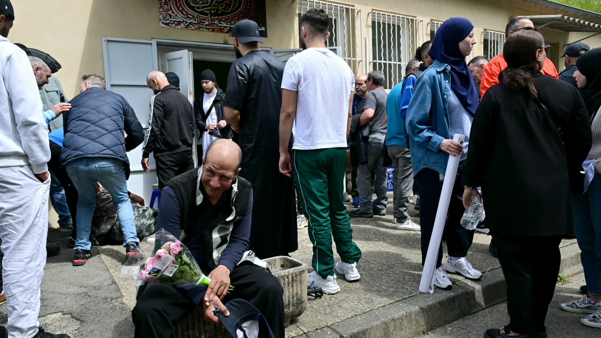 Un homme tient des fleurs devant la mosquée Khadija à La Grand-Combe, dans le sud de la France, le 27 avril 2025, avant une marche en hommage à Aboubakar, un fidèle tué de plusieurs dizaines de coups de couteau à l'intérieur de la mosquée le 25 avril. 