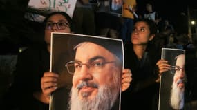 Des manifestants brandissent des photos d'Hassan Nasrallah, ancien chef du groupe libanais Hezbollah, lors d'une veillée de protestation dans la ville de Sidon, dans le sud du Liban, le 28 septembre 2024. 