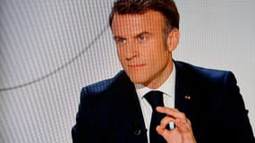 Un écran de télévision diffusant le président français Emmanuel Macron lors d'une interview en direct sur les chaînes de télévision françaises TF1 et France 2 à l'Elysée à Paris le 14 mars.