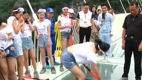 Une vingtaine de bénévoles ont testé la solidité d'un pont en verre en Chine à coups de marteau.