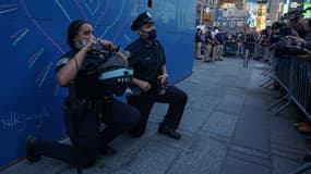 Deux policiers mettent leur genou à terre sur la célèbre place Time Square, à New York, en solidarité avec les manifestants, le 31 mai.