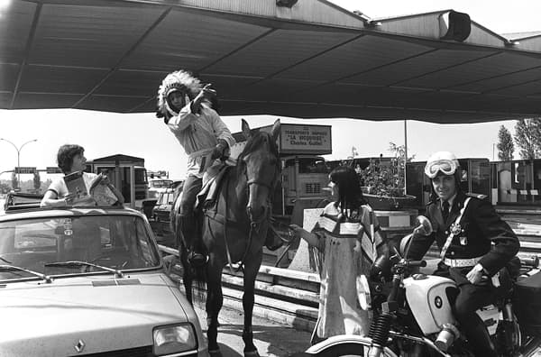 Photo prise le 28 juin 1977 sur une autoroute française d'un homme à cheval déguisé en Indien donnant des indications à une automobiliste, lors d'une opération de "Bison Futé" de distribution de cartes routières.
