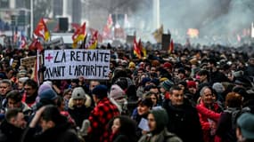 Une personne manifestant tient une pancarte sur laquelle est écrit "La retraite avant l'arthrite" lors d'un rassemblement à Lyon le 19 janvier 2023.