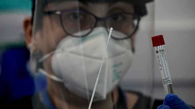 Une infirmière pose avec un écouvillon de test dans un centre de test à l'aéroport de JFK à New York, le 29 juin 2020.  