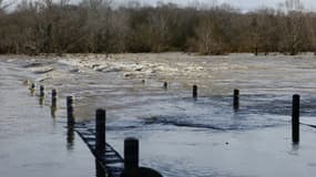 Un pont submergé par les eaux lors d'inondations à Dions, dans le Gard, le 10 mars 2024