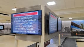 Un écran annonce l'arrêt des vols à l'aéroport Reagan de Washington après la collision entre un avion et un hélicoptère militaire, le 29 janvier 2025