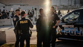 Un groupe de policiers locaux observe depuis l'autre côté de la rue les manifestants qui se rassemblent et chantent dans la "zone de libre expression" devant le centre de traitement et de détention de l'Immigration and Customs Enforcement, le 31 octobre 2025, à Broadview, dans l'Illinois (image d'illustration).
