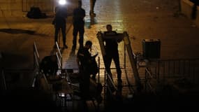 Des policiers israéliens désinstallent les détecteurs de métaux, dans la nuit du 24 au 25 juillet, à Jérusalem. 