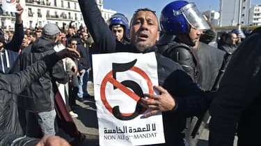 Un manifestant brandit une pancarte avec un "5" barré et une inscription "Non au 5e mandat" d'Abdelaziz Bouteflika, le 22 février 2019 à Alger.