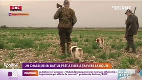 Un chasseur en battue prêt à tirer à travers la route 