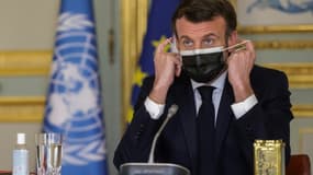 Le président français Emmanuel Macron ajuste son masque lors d'une visioconférence du Conseil de sécurité de l'ONU le 23 février 2021
