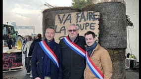 Les trois députés du RN devant la pancarte insultante