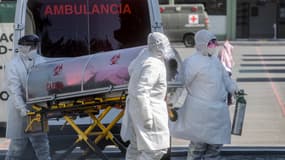 Les ambulanciers paramédicaux déplacent un patient soupçonné d'être infecté par le nouveau coronavirus à l'hôpital de la police militaire, à Mexico, le 30 décembre 2020.